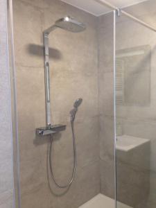 een douche met een douchekop in de badkamer bij Comfort Aan Zee Guestrooms in Oostende