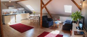 a living room with two blue chairs and a kitchen at Apartment House Timisoara in Timişoara