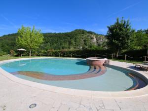 a large swimming pool with a bench around it at Belvilla by OYO Casa Ginepro in Apecchio