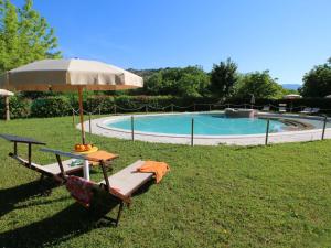 een tafel en een parasol naast een zwembad bij Belvilla by OYO Casa Ginepro in Apecchio