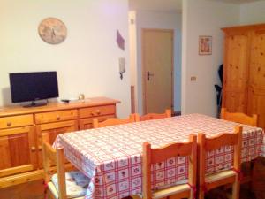 a dining room with a table and a tv on the wall at Lovely Chalet in Pozza di Fassa with Garden in Pozza di Fassa