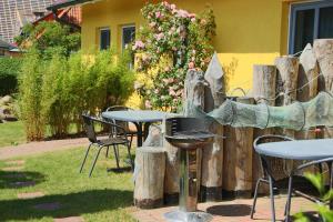 a patio with tables and chairs and a fence with flowers at Ferienwohnungen Thorsten Fründt in Prerow