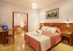 sypialnia z łóżkiem i biurkiem z laptopem w obiekcie Gran Hotel De La Paix w BuenosAires