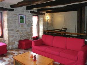 uma sala de estar com um sofá vermelho e uma mesa em Vintage holiday home near Rodez in Aveyron em Muret-le-Château