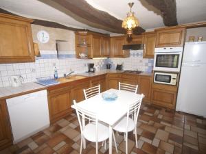 cocina con mesa blanca y electrodomésticos blancos en Vintage holiday home near Rodez in Aveyron, en Muret-le-Château