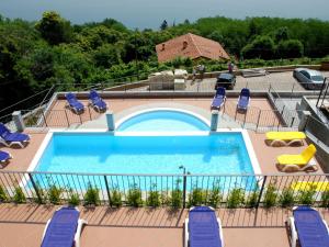 a large swimming pool with lounge chairs at Belvilla by OYO Panoramica in Oggebbio