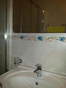 a bathroom sink with a mirror and aaucet at Villa Nikola Kentera in Sveti Stefan
