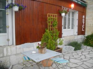 un patio avec une table et des chaises devant un bâtiment dans l'établissement Le Parisien, à Saintes
