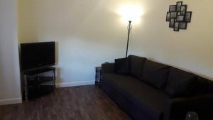 a living room with a couch and a flat screen tv at Sunnyside Apartments in Coatbridge