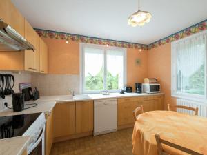 a kitchen with wooden cabinets and a table in it at Modern vacation home with private garden in Bathernay