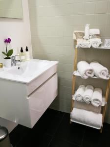 a bathroom with a sink and a shelf with towels at Pontocom Bolhão Apartment in Porto