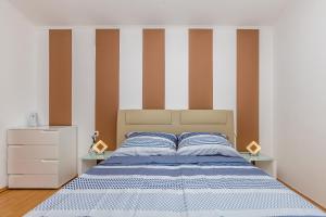 Un dormitorio con una cama con paredes rayadas. en Apartments Jenny, en Pinezici 24 fotos más