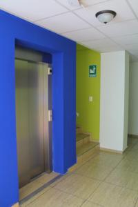 a hallway with a blue column and stairs in a building at Hostal de Asturias in San Salvador +8 photos