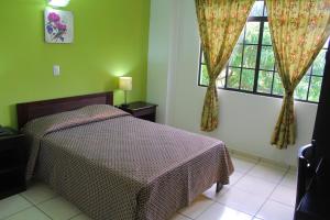 a bedroom with a bed and two windows at Hostal de Asturias in San Salvador
