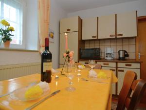 a table with a bottle of wine and glasses on it at Cosy holiday home in the Upper Palatinate Forest with a fenced garden and seating corner in Stadlern