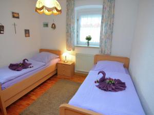 2 Betten in einem kleinen Zimmer mit lila Bademänteln in der Unterkunft Cosy holiday home Palatinate Forest in Stadlern