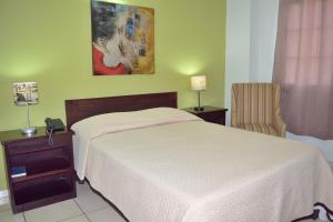 a hotel room with a bed and a chair at Hostal de Asturias in San Salvador +8 photos