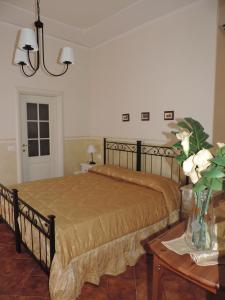 Chiantirooms Guesthouse في غريفي ان شنتي: غرفة نوم بسرير وطاولة مع ورد