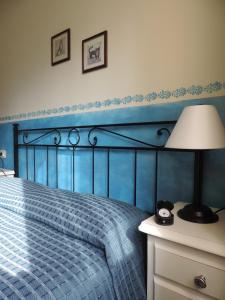 グレーヴェ・イン・キアンティにあるChiantirooms Guesthouseの青いベッドルーム(ベッド1台、ランプ付)