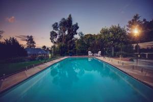 a large swimming pool in a yard at night at Evanslea Luxury Boutique Accommodation in Mudgee