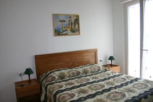 1 Schlafzimmer mit einem Bett mit einer Bettdecke und 2 Lampen in der Unterkunft B&B La Baia Di Fiascherino citr01101sei-BEB-0011 in Tellaro