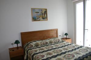 a bedroom with a bed with a comforter and two lamps at B&B La Baia Di Fiascherino citr01101sei-BEB-0011 in Tellaro