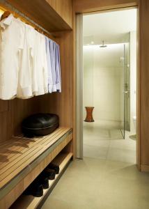 a bathroom with a walk in shower and a black ottoman at Capri by Fraser Changi City, Singapore in Singapore