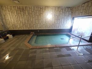 a swimming pool in a room with a tile floor at Hotel Route-Inn Nishinasuno in Nasushiobara