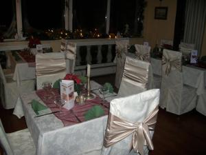 a table with white chairs and a table with wine glasses at Hotel Viktória in Balatonalmádi