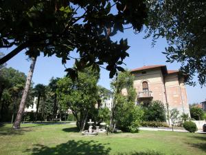 um edifício num parque com relva verde e árvores em Belvilla by OYO Villa Melina em Desenzano del Garda