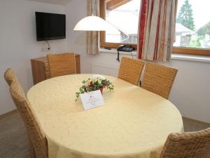 a dining room table with a flower arrangement on it at Stylish Flats in Uderns near Ski Lift in Uderns