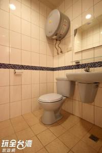 a bathroom with a toilet and a sink at ZaiXiang in Tamsui