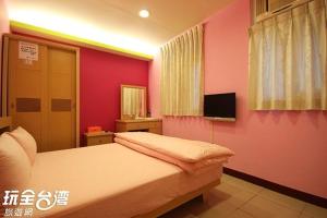 ein Schlafzimmer mit einem großen Bett und einem Fernseher in der Unterkunft ZaiXiang in Tamsui