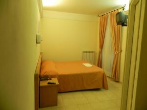 a small bedroom with a bed and a window at Hotel Il Saraceno in Volastra