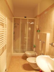 a bathroom with two toilets and a shower and a sink at Hotel Il Saraceno in Volastra