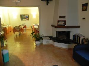 a living room with a fireplace and tables and chairs at Hotel Il Saraceno in Volastra