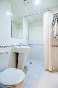 高雄的住宿－三多旅店，白色的浴室设有卫生间和水槽。