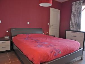Schlafzimmer mit roten Wänden und einem Bett mit einer roten Bettdecke in der Unterkunft Luxury villa with pool in Thermes Magnoac in Thermes-Magnoac