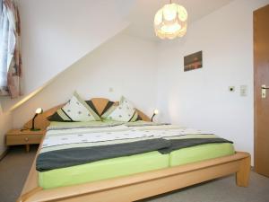 Spacious apartment near Lake Constance في Ahausen: غرفة نوم مع سرير مع لحاف أخضر وأسود