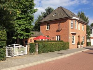 a brick house with a white fence in front of it at Spacious Villa in Neerpelt near Welvaart Marina in Neerpelt
