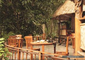 a group of chairs and a table and a hut at The Barefoot At Havelock in Havelock Island