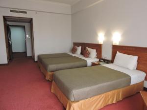 Postel nebo postele na pokoji v ubytování Hotel Grand Continental Kuching