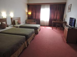 Postel nebo postele na pokoji v ubytování Hotel Grand Continental Kuching