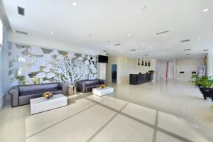 a lobby with couches and a mural of birds at Whiz Prime Hotel Sudirman Cilacap in Cilacap