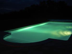 una piscina con luces verdes en la oscuridad en Detached villa in a beautiful area, en La Croix-Blanche