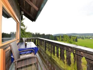 a table and chairs on the balcony of a house at Holiday home with terrace in Weigelsberg