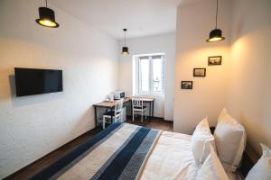 a bedroom with a bed and a desk with a television at Citadel Express in Tbilisi City