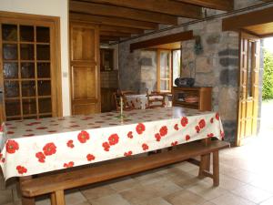 uma cama grande com flores vermelhas num quarto em Comfy holiday home with private garden em Neuvéglise