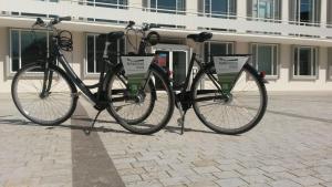 dos bicicletas están estacionadas frente a un edificio en Burkardushaus, Tagungszentrum am Dom, en Würzburg