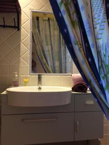 La salle de bains est pourvue d'un lavabo et d'un miroir. dans l'établissement l'Oustaou B&B Piscine & Spa, à Besse-sur-Issole
